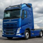 Niebieski ciągnik siodłowy Volvo FH na placu pod pochmurnym niebem