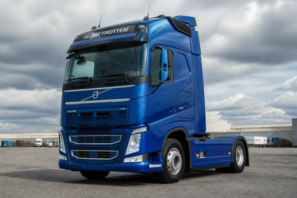 Niebieski ciągnik siodłowy Volvo FH na placu pod pochmurnym niebem